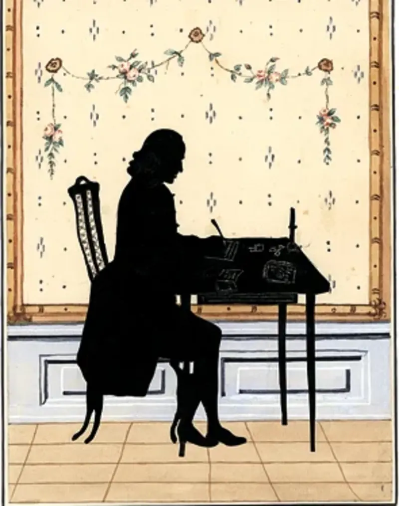 Silhouette eines am Schreibtisch sitzenden Mannes